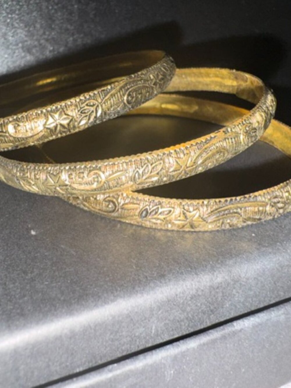 Set of three brass colored bracelets